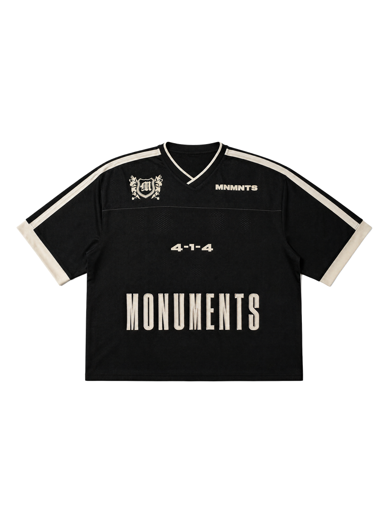 MONUMENTS 4-1-4 boxy oversized jersey in black mesh with eggshell shoulder panels and contrast sleeve trim, front view.