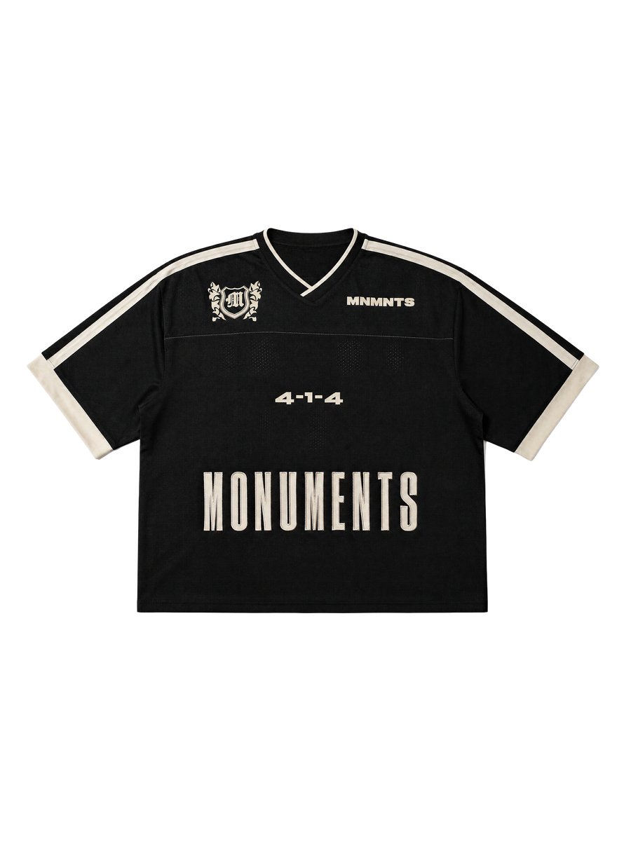 MONUMENTS 4-1-4 boxy oversized jersey in black mesh with eggshell shoulder panels and contrast sleeve trim, front view.