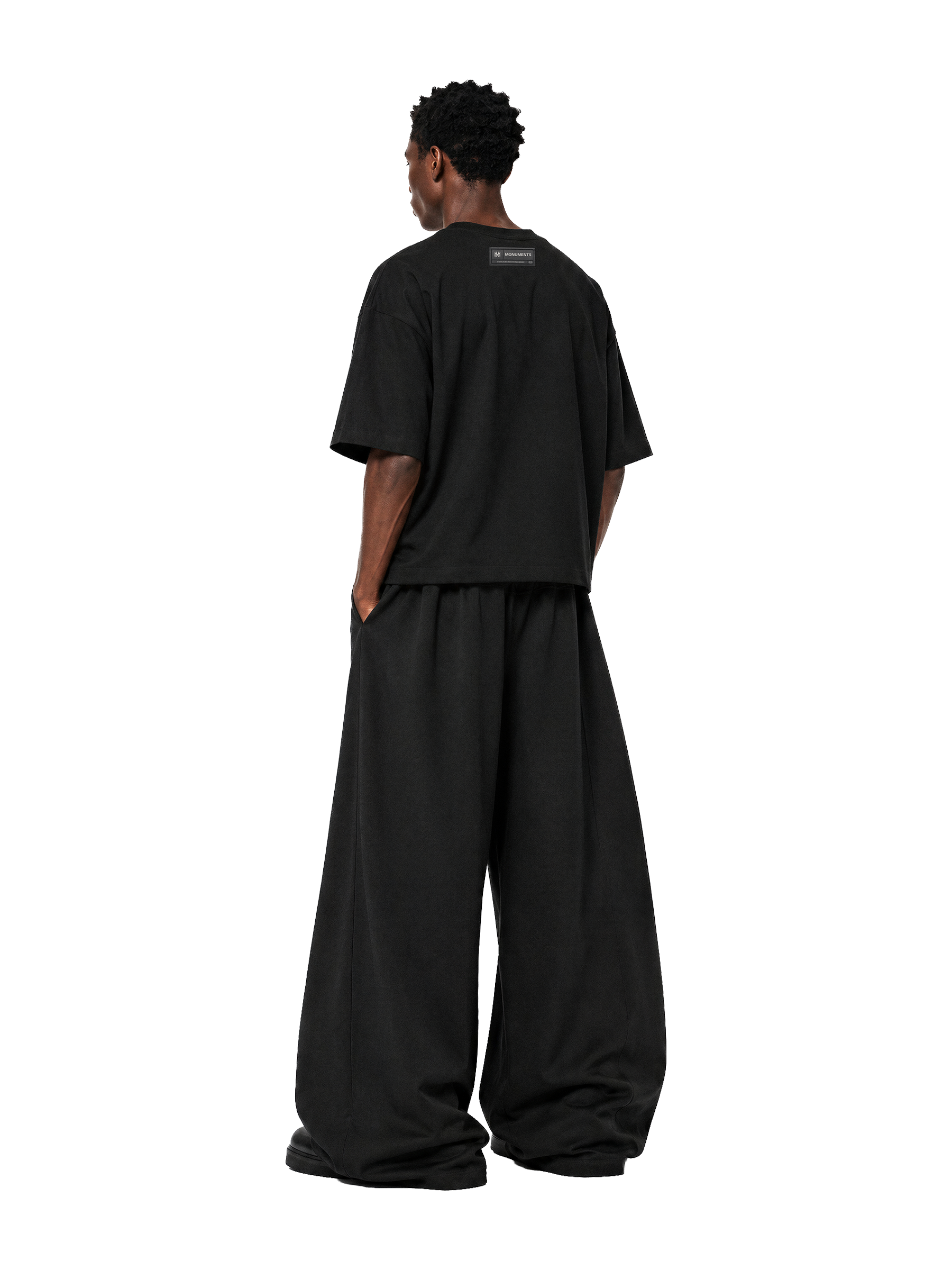 Back of the MONUMENTS MM core logo cropped boxy tee in black cotton.