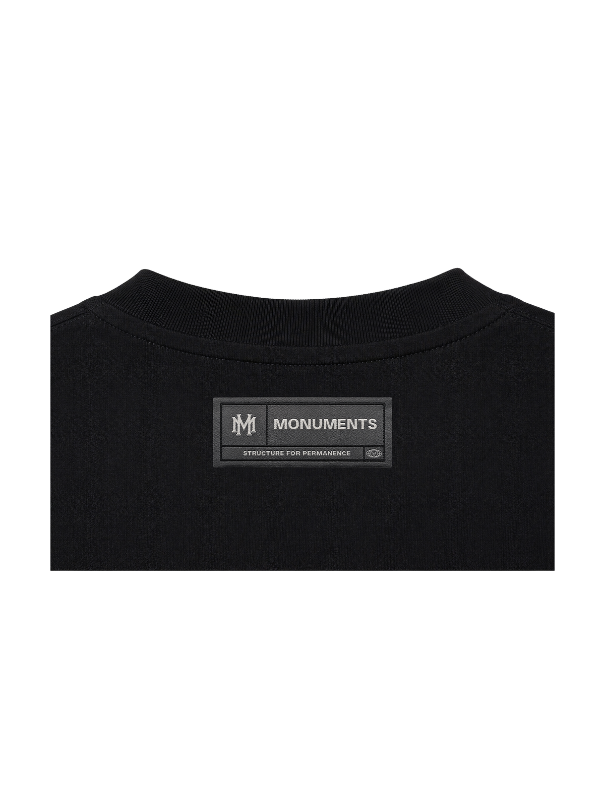 Woven MONUMENTS back-neck label on the black MM core logo boxy tee.