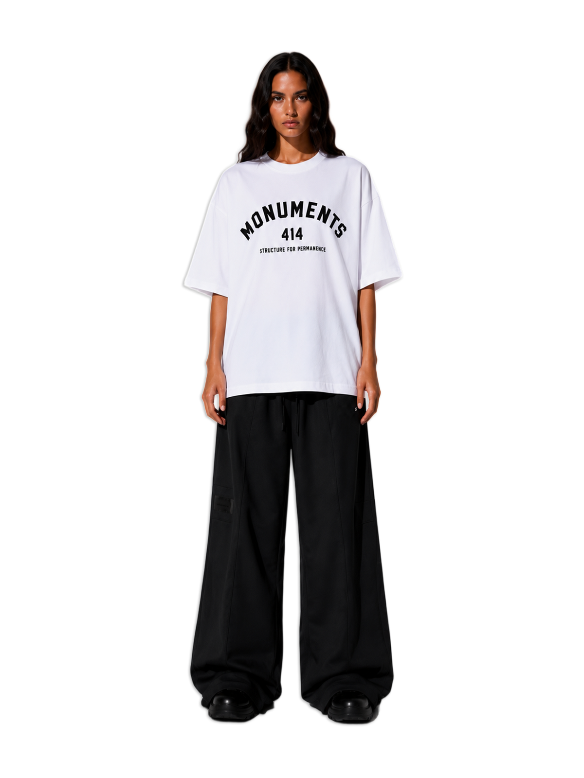 Model wearing the white MONUMENTS 414 Structure oversized tee with black wide-leg trousers, front view.
